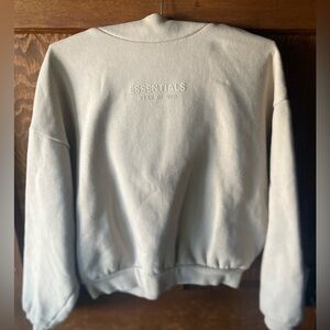 Fear of God Essentials hoodie in oatmeal beige color.